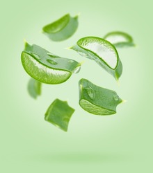 Aloe Vera Slices Flying Composition On Green Background. Skin Care Concept