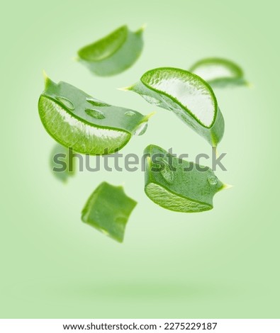 Aloe vera slices flying composition on green background. Skin care concept