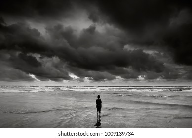 alone boy near the beach with dramatic stormy sky   during monsoon season 
