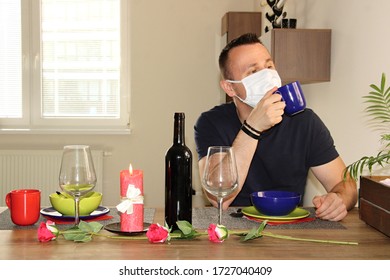 Alone Despairing Man Sitting Near Arranged Table For Romantic Dinner And Waiting For Date Partner. Failed Date With One Person. Boy Wearing Face Mask To Protect From Coronavirus.