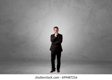 Alone handsome businessman standing in a dark empty room - Powered by Shutterstock