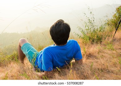 alone man lying and looking view on mountain. subject is blurred and low key