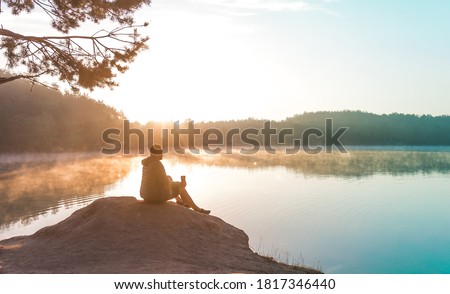 Alone man meditating and relaxing on beautiful nature. Travel and healthy Lifestyle concept lake and mountains sunny landscape on background outdoor. Sustainable climate visuals