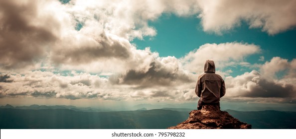 alone man sitting on the peak of mountain cloudy sky
lonely scene, waiting for hope, landscape panorama view, copy space