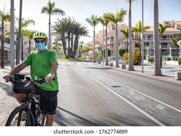 Alone Man With Yellow Helmet And Tshirt Cycling In Tenerife In The Deserted City Street Due To Coronavirus, Crisis Of Tourism