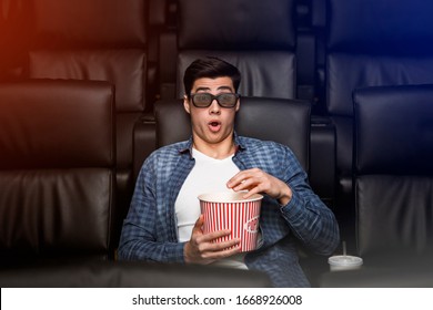 Alone in the movies. Young guy with shocked look on his face in film theater - Powered by Shutterstock