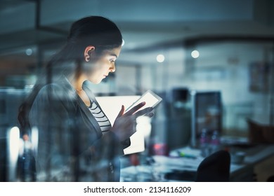 Alone In The Office Getting Work Done. Shot Of A Young Businesswoman Working Late In The Office.