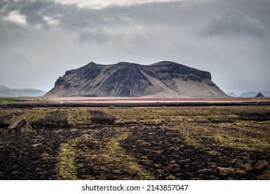 Alone rocky volcanic mountain in desert terrain. Iceland