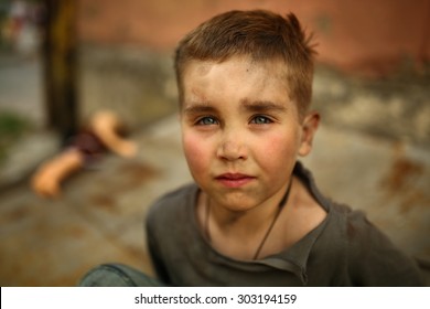 Alone Sad Child Playing On A Street