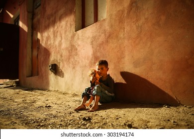 Alone Sad Child Playing On A Street