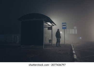 Alone sad man waiting for bus at bus stop.