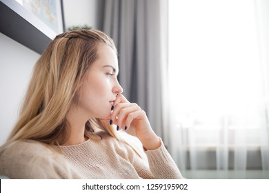Alone sad woman thinking about something while sitting at home