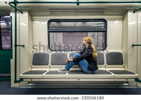 Alone in the subway. A blonde woman sitting in subway train and looking at window
