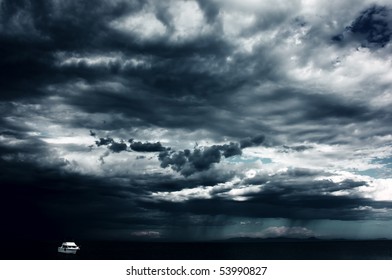 Alone white little boat on sea and dark storm clouds