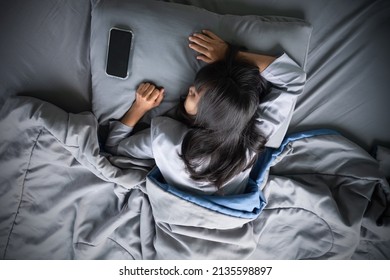Alone woman on gray bed with mobile phone at home. she sad and lonely. relax in night. health and broken heart concept. - Shutterstock ID 2135598897