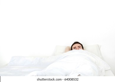 Alone Young Man In A Bed Under A White Blanket