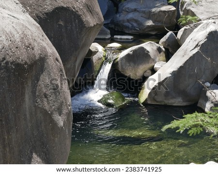 Along the river on the hiking path to La Chapelle in Cilaos, Reunion island. Freshwater flowing in ponds and boulder rock in La Réunion. 