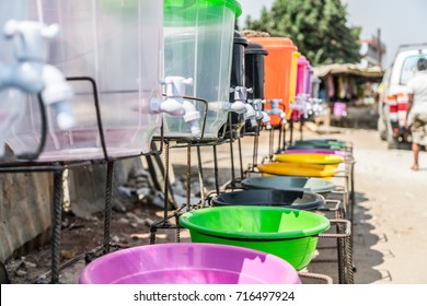 Along a road in Lusaka a city in Zambia colorful jars are waiting to be sold. Like a rainbow they stand and collect the dust. Empty they're waiting until the time comes and someone fills them up.