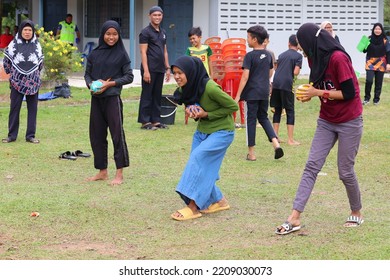 Alor Setar, Kedah, Malaysia - September 20th, 2022 : Group Of People  Men, Women And Kid Playing Water Balloon Game. Summer Fun Outdoor Activities Concept.