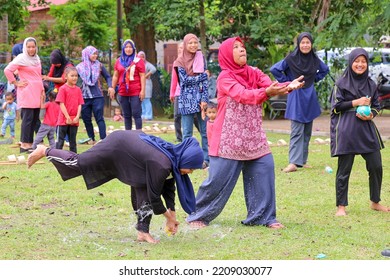 Alor Setar, Kedah, Malaysia - September 20th, 2022 : Group Of People  Men, Women And Kid Playing Water Balloon Game. Summer Fun Outdoor Activities Concept.