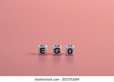Alphabet beads with text EGO isolated on pink background