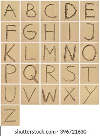 Alphabet drawing or writing in the sand. Arrangement of letters in the sand.
