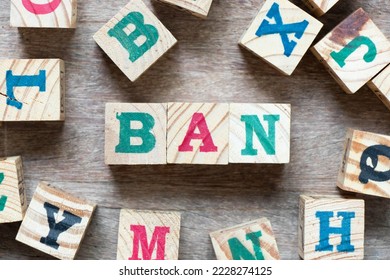 Alphabet letter block in word ban and another letter on wood background - Shutterstock ID 2228274125