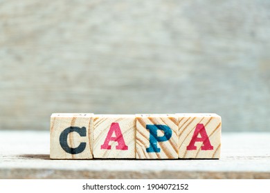 Alphabet letter block in word CAPA (abbreviation of corrective action and preventive action) on wood background