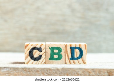 Alphabet letter block in word CBD (Abbreviation of Central business district or Cannabidiol) on wood background