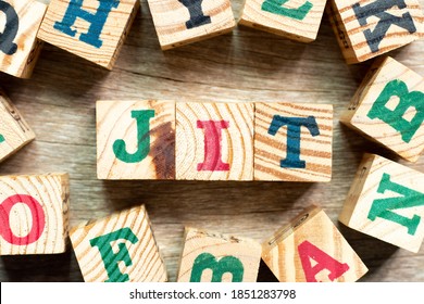 Alphabet letter block in word JIT (abbreviation of just in time) with another on wood background