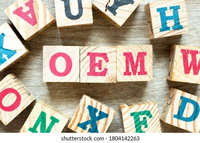 Alphabet letter block in word OEM (Abbbreviation of Original Equipment Manufacturer) with another on wood background
