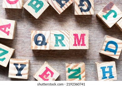 Alphabet Letter Block In Word QRM (Abbreviation Of Quality Risk Management) And Another Letter On Wood Background