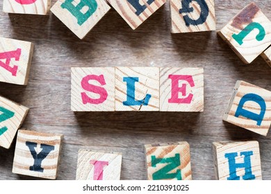 Alphabet letter block in word SLE (Abbreviation of Systemic lupus erythematosus) and another letter on wood background - Shutterstock ID 2210391025