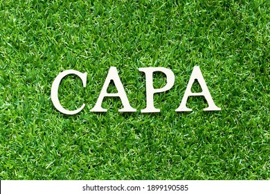 Alphabet letter in word CAPA (abbreviation of corrective action and preventive action) on green grass background