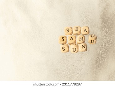 Alphabet letter wording "Sea Sand Sun" bead toy flying over explosion flying in air. Sea Sand Sun word alphabet letter show tropical island beach white sand for vacation holiday. Top view action - Shutterstock ID 2311778287