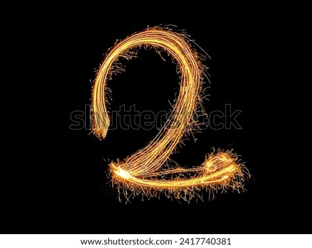 Alphabet and Number two sparklers on black background by light painting.number 2 sparkling golden for party and Celebrate.