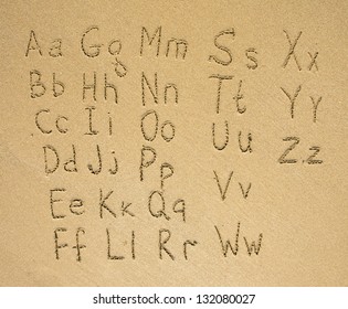 The alphabet written on a sand beach.