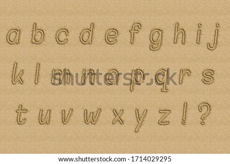 Alphabet written on the shore of a beach