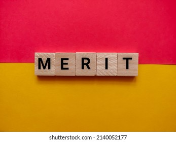 Alphabetical Letters With The Word Merit On A Red And Yellow Background. Business And Merit Concept.