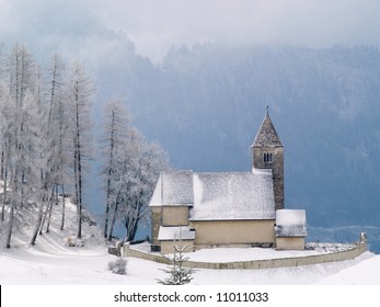 Alpine Church after morning snowfall in mountain village of Falera, Switzerland