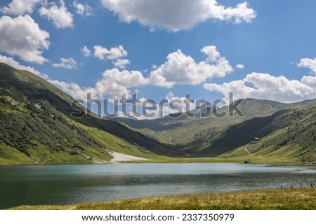 Alpine Lake with Hilly Landscape in Austria. Tappenkarsee with Green European Scenery and Blue Sky with Clouds.