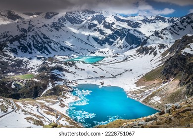 Alpine lake and mountain road at springtime, Gran Paradiso Alps, Italy