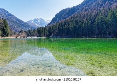 Alpine Lake With Treeline, Hills And Mountain Peak In Background