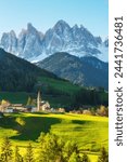 Alpine landscape with Santa Maddalena village against the Geisler mountains covered with snow at sunrise, Val Di Funes in Dolomites mountains, Trentino Alto Adige, Italy. Vertical orientation