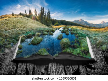Alpine mountain valley in a light of sunrise on the pages of an open magical book. Majestic landscape. Nature concept.