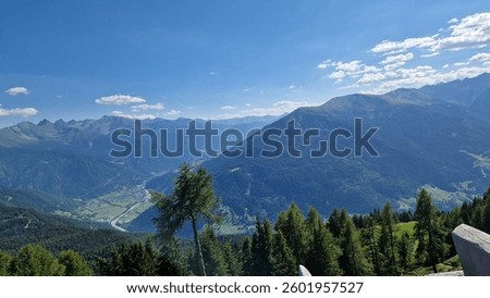 Alpine Panorama: Sweeping mountain range emerges from a blanket of clouds, revealing crisp blue skies.