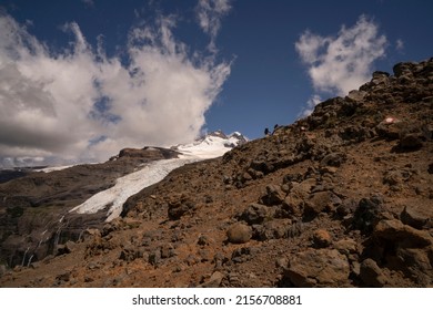 Alpine scenic. View of two hikers climbing up Tronador hill and glacier Castaño Overo in the Andes mountains in Patagonia Argentina. The rocky mountaintop and glacier ice field under a majestic sky. - Shutterstock ID 2156708881