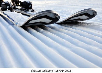 Alpinski im Schnee auf präpariertem Hang