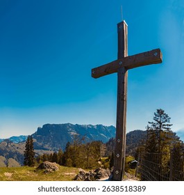 Alpine spring view with a summit cross and Mount Zahmer Kaiser in the background at Kaiserlift Kufstein, Tyrol, Austria