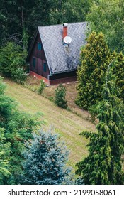 Alpine Style Wooden House In Green Forest From Aerial View
